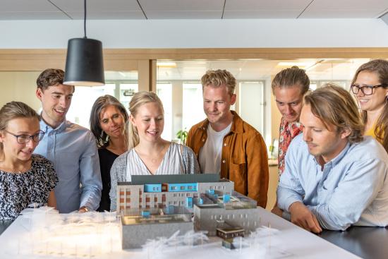 En fysisk modell av Västra Varvstaden tillsammans med de konstruktörer och arkitekter som arbetat med projektet genom ett integrerat arbetssätt.