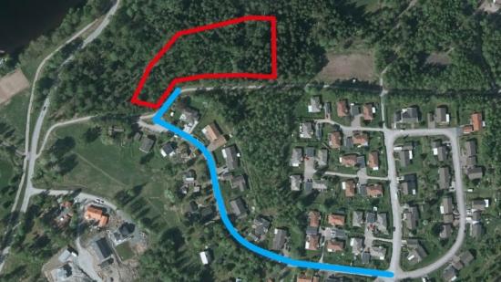 Planerad anslutningsväg (blå) till nytt bostadsområdet (rött).