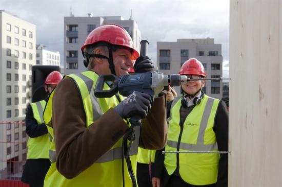 Bostadsminister Per Bolund (MP) hjälpte till att montera de första trästommarna till de nya bostadshusen.