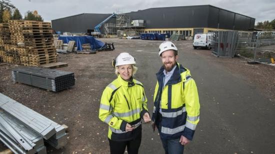 Lars Ekblom (projektchef från Caverion) tillsammans med Kristin Folkesson (projektledare från ByggDialog) framför byggandet av Hammaröskolan.