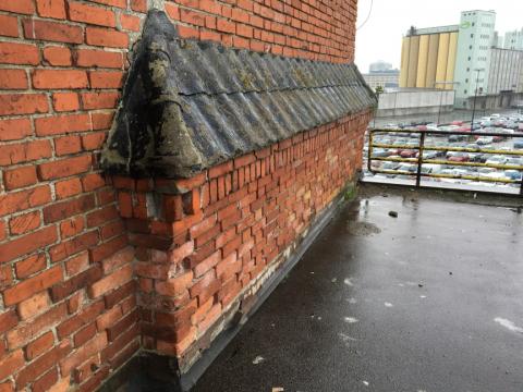 Delar av fastighetens tegelfasad.