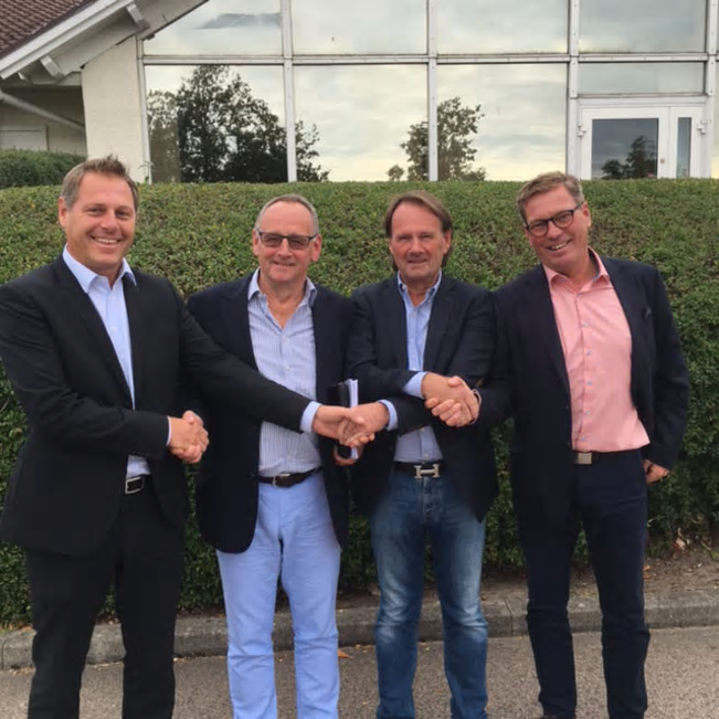 Bravidas Anders Ahlquist och Mats Karlsson på varsin kant skakar hand med bröderna Lars och Anders Nilsson vid signeringen